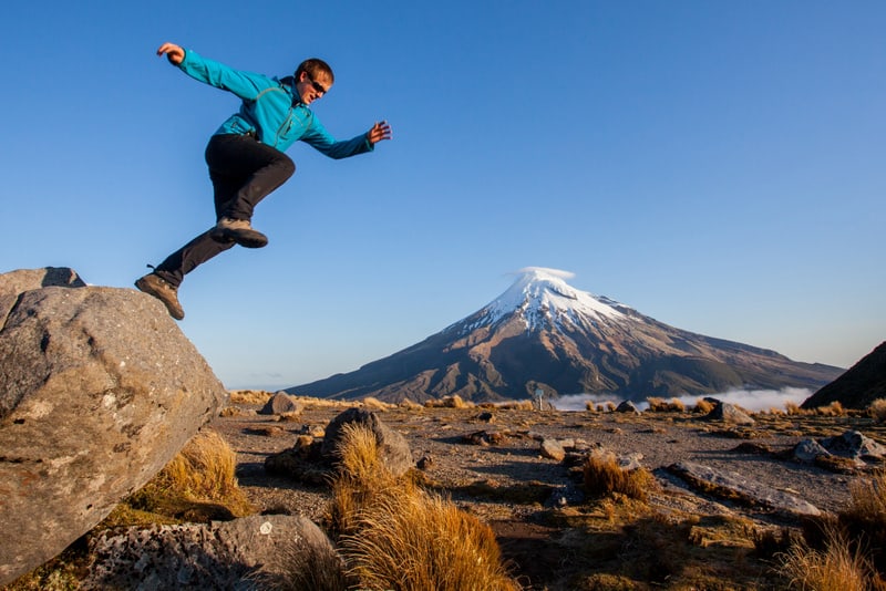 Young man jumping above volcano summit