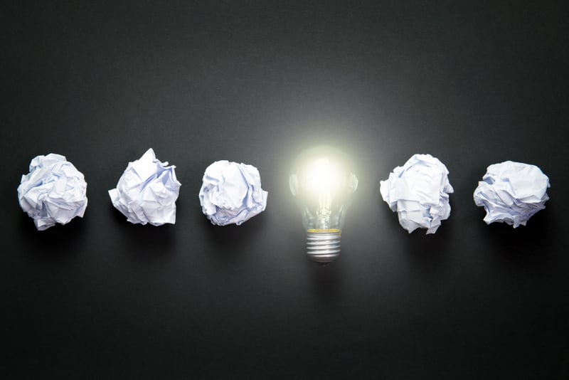 Light bulb in a row with crumpled paper as creative concept