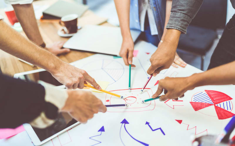 Creative idea teamwork concept. Group of multiethnic diverse team, business partner, or college students in project meeting at modern office. Five people pointing at lightbulb drawings
