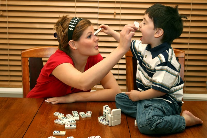 A mother and her son playing dominoes