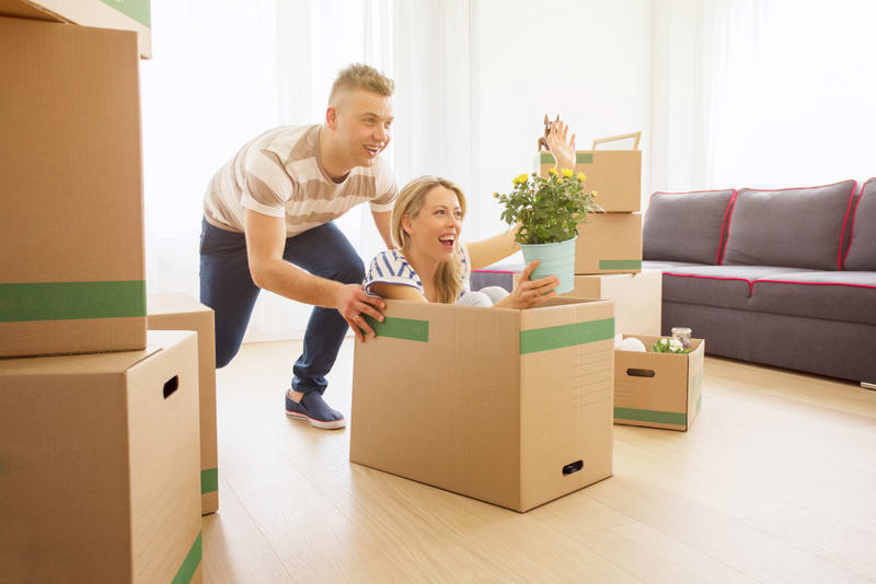 Funny couple having fun while moving into new apartment