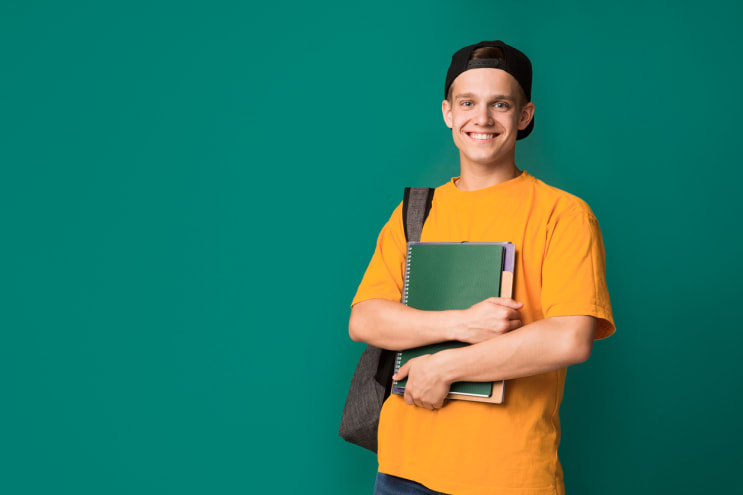 Happy student with books and backpack over background stock photo